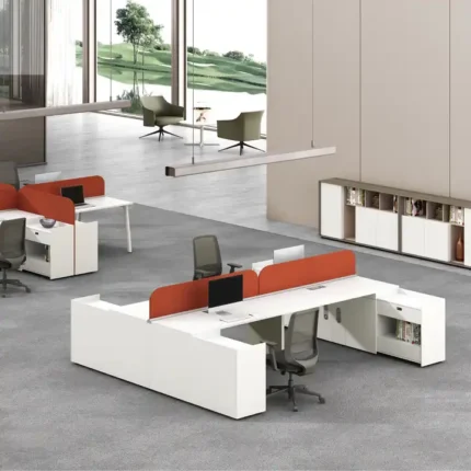 A modern, spacious workstation with a white desk, built-in storage compartments, and an ergonomic chair with a grey backrest and orange cushion